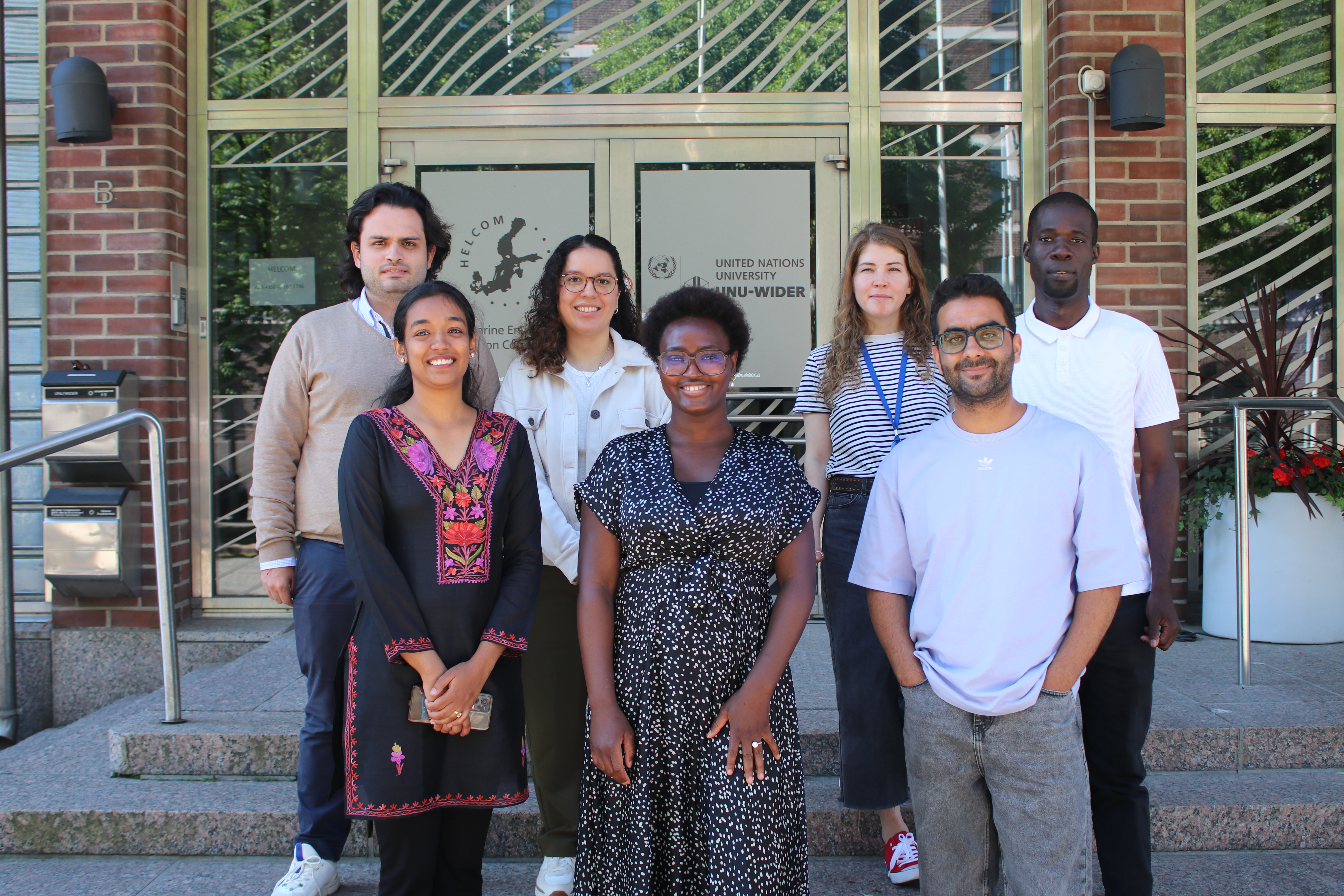 Krishna with the spring 2024 cohort of Visiting PhD fellows in front of UNU-WIDER Helsinki office.