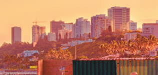 Photo of sunset in Maputo, Mozambique. Photo includes a beach and high-rise buildings in the background.