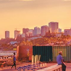 Photo of sunset in Maputo, Mozambique. Photo includes a beach and high-rise buildings in the background.