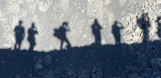 Shadows of group of people on a rocky surface.